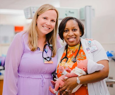 Two doctors holding a baby