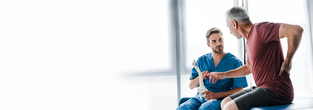 Provider and patient discuss a model of the spine