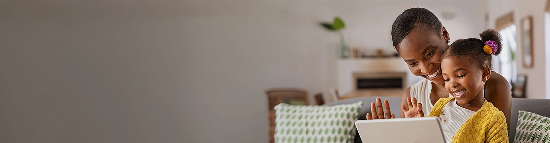 Mother and daughter waving at computer.