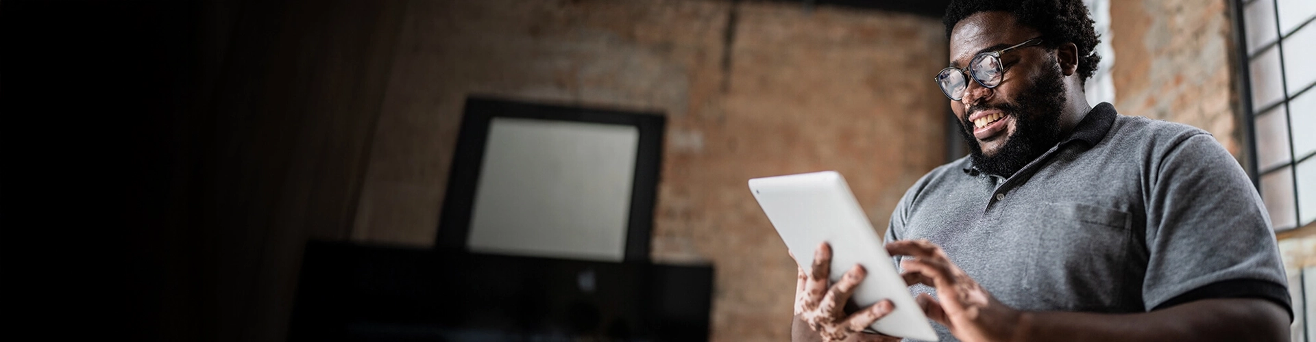 smiling man looks at an iPad